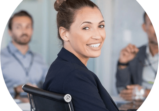 A woman sitting in a chair with other people behind her.